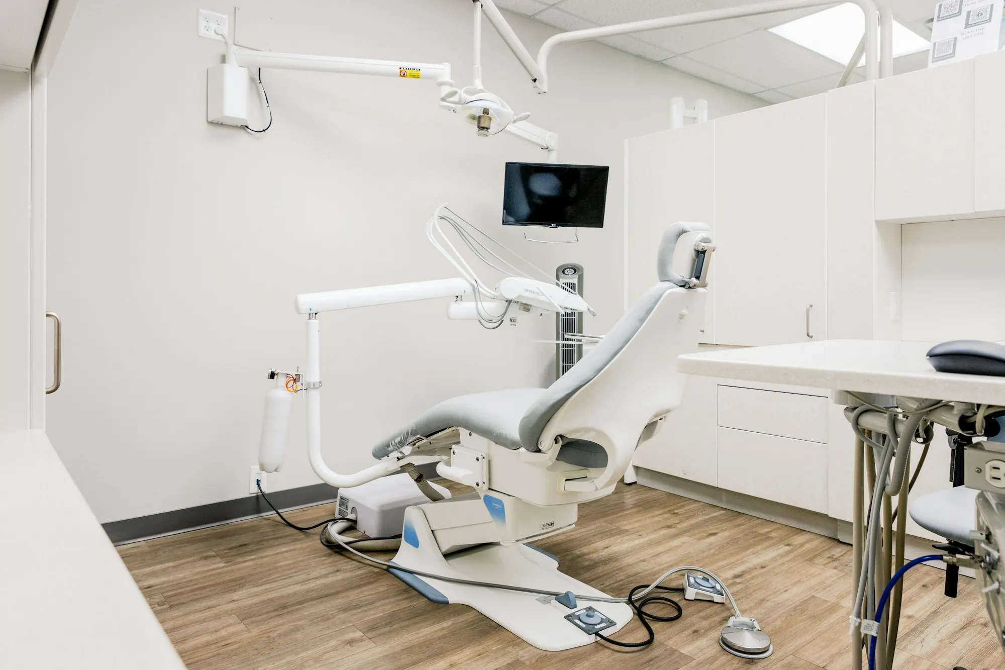 Bir diş kliniğinin tedavi odası: ünit, tezgâh ve üzerinde açık duran sarf malzeme paketleri